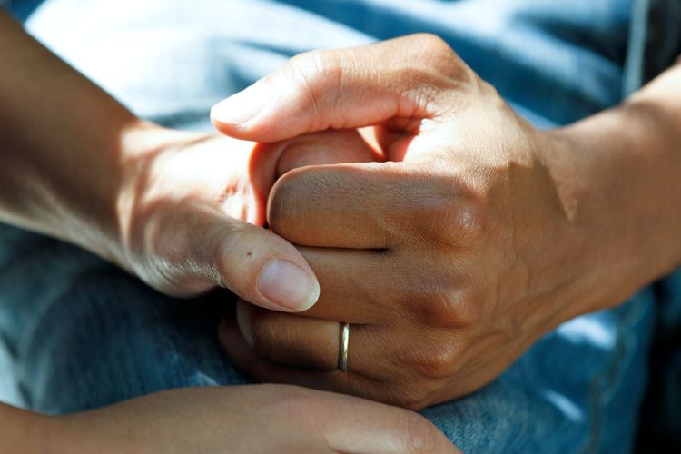 two hands holding as women discuss trauma healing