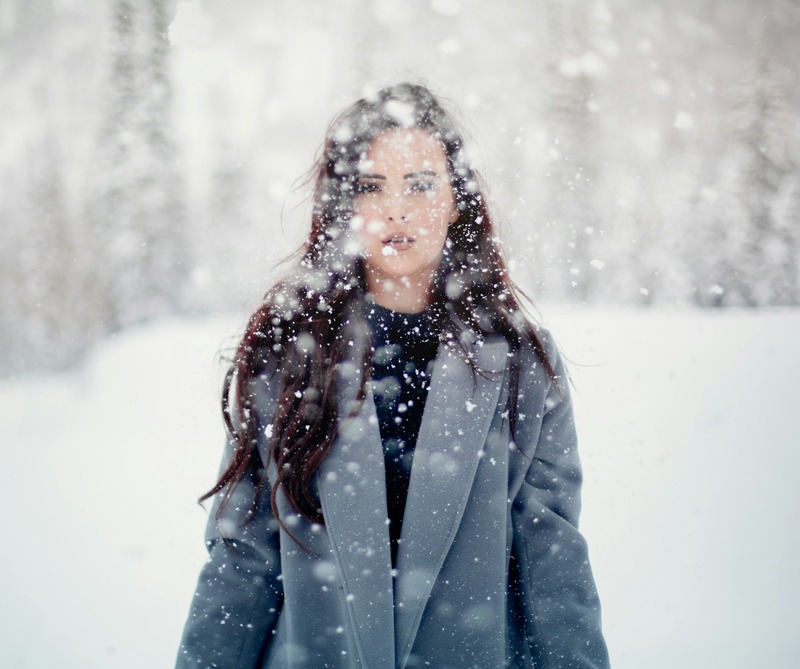 woman standing in snow storm reflecting on her childhood experiences